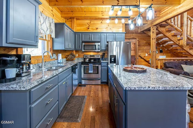 2430 Cobbler Way, Pigeon Forge, TN 37863 - kitchen with appliances with stainless steel finishes, a wood ceiling with exposed beams, dark wood-style floors, light stone countertops, and a kitchen island