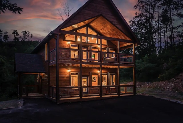 back house at dusk with a balcony