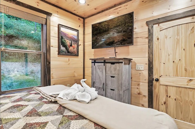 bedroom with wood ceiling, multiple windows, and wood walls