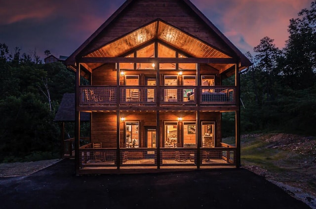 back house at dusk with a balcony