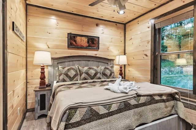 bedroom with wood walls, ceiling fan, wood-type flooring, and wooden ceiling