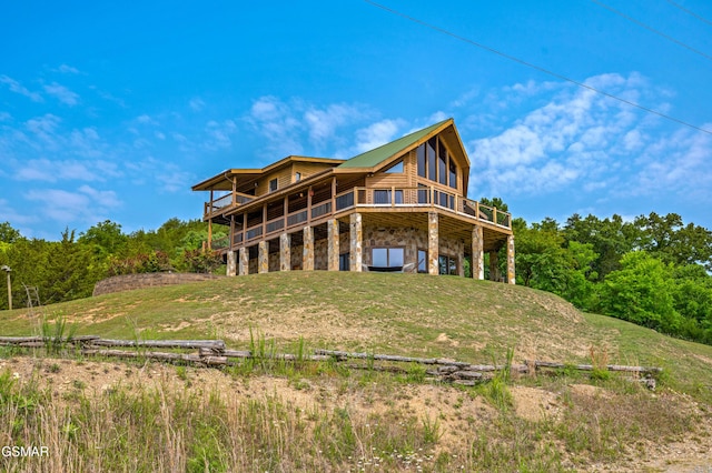 rear view of property featuring a carport and stone siding