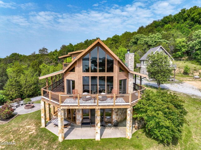 3829 Island View Rd, Sevierville, TN 37876 - rear view of property with a fire pit, stone siding, a patio, a wooden deck, and a yard