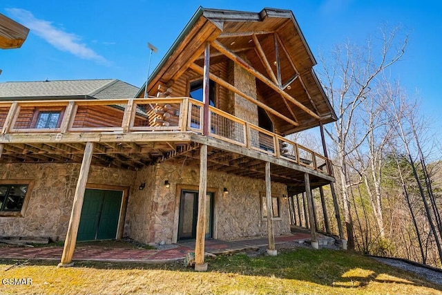 rear view of house with log siding, roof with shingles, and a wooden deck