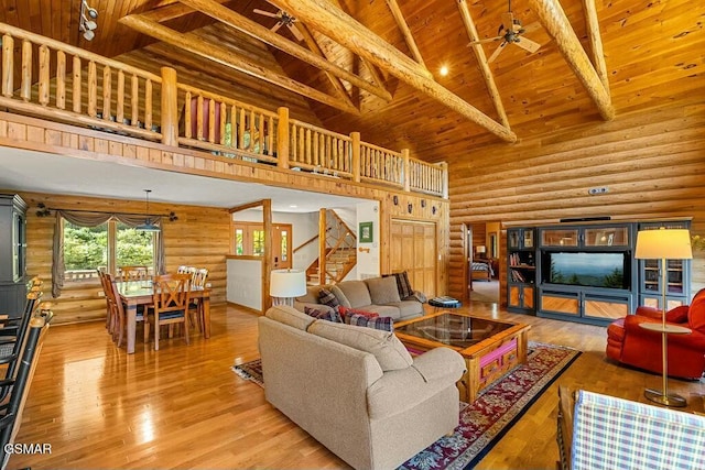 living room with stairway, high vaulted ceiling, hardwood / wood-style flooring, wooden ceiling, and beamed ceiling