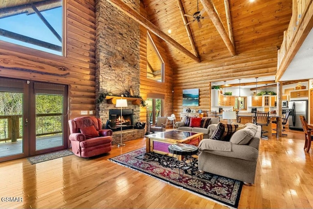 living area featuring wooden ceiling, light wood-style flooring, vaulted ceiling with beams, and a fireplace