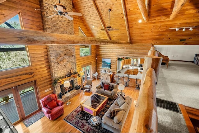 living room with beamed ceiling, wooden ceiling, high vaulted ceiling, and wood finished floors