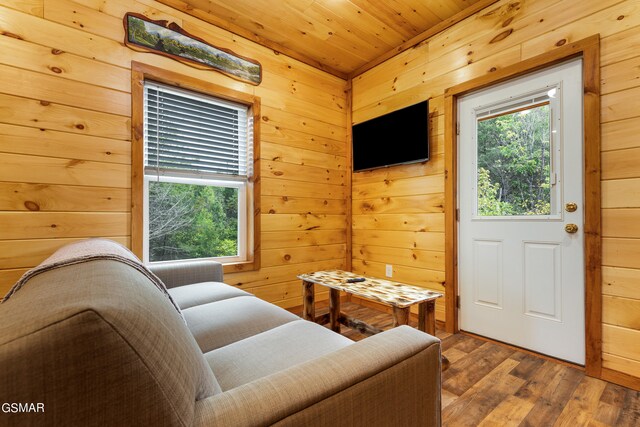 living area featuring wooden walls, wooden ceiling, and hardwood / wood-style flooring