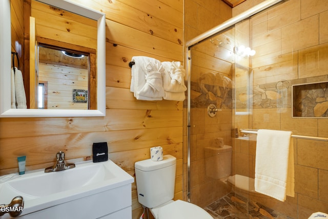 bathroom featuring vanity, toilet, a shower with door, and wood walls