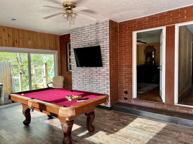 game room featuring ceiling fan, brick wall, a textured ceiling, and pool table