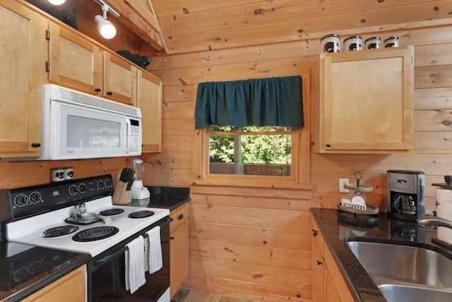 kitchen featuring wood walls, sink, and white appliances