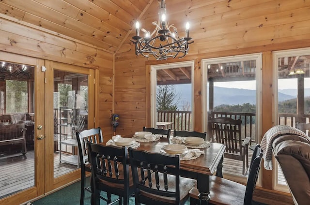 dining room with a chandelier, wooden walls, wooden ceiling, and lofted ceiling