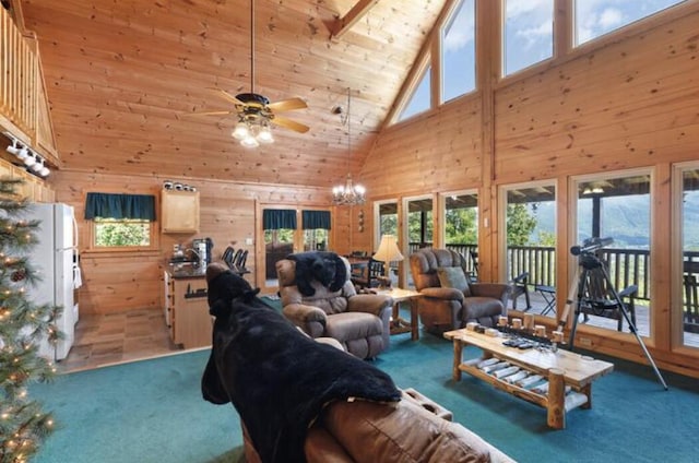 carpeted living room featuring wood walls, high vaulted ceiling, wood ceiling, and ceiling fan with notable chandelier