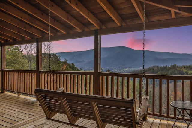 deck at dusk featuring a mountain view