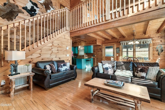 living room featuring wood walls, light wood-type flooring, wood ceiling, and a chandelier