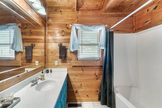 bathroom with tile patterned flooring, vanity, wood walls, and shower / bath combo