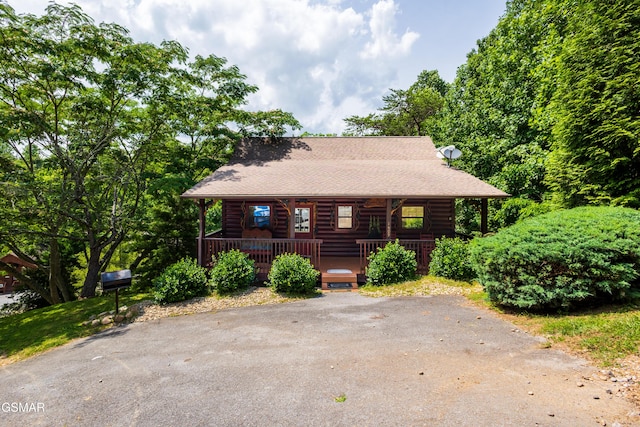 1609 Pinewood Way, Sevierville, TN 37862 - log-style house featuring a shingled roof, covered porch, asphalt driveway, and log siding