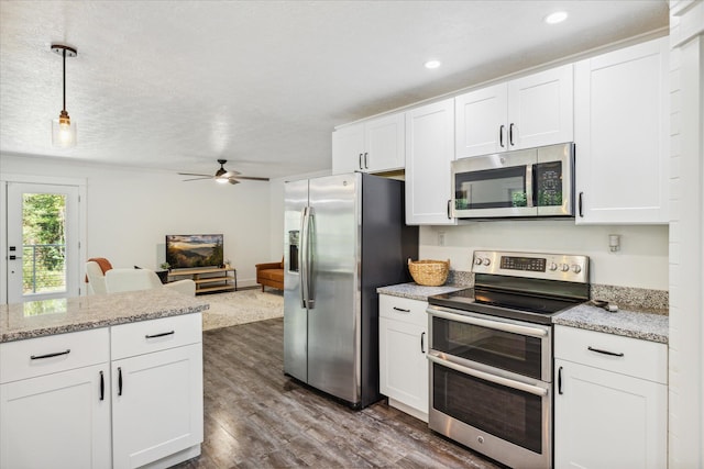 kitchen featuring appliances with stainless steel finishes, light stone counters, ceiling fan, pendant lighting, and white cabinets