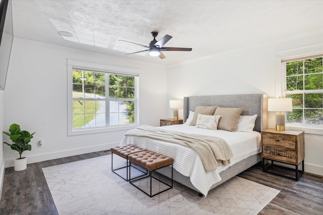 bedroom with ornamental molding, ceiling fan, and dark wood-type flooring