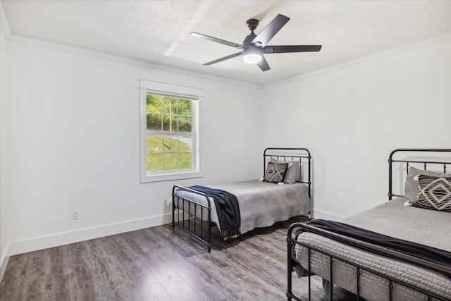 bedroom featuring hardwood / wood-style flooring, ceiling fan, and crown molding