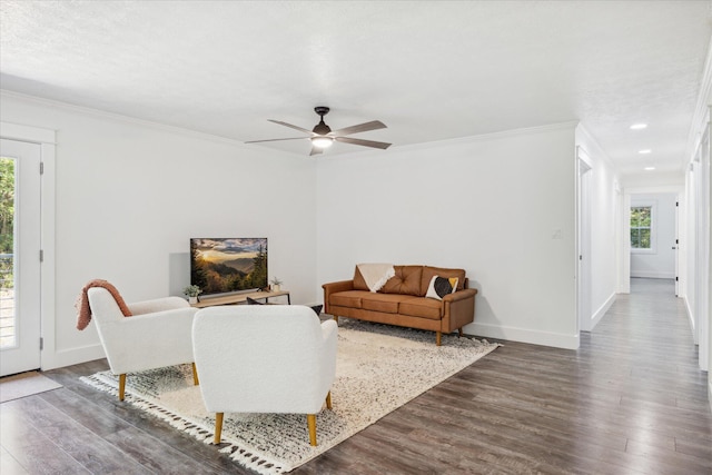 living room featuring dark hardwood / wood-style floors, ceiling fan, and crown molding