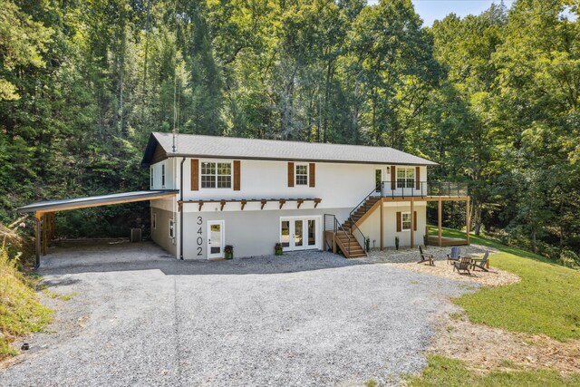 view of front of house with french doors, a carport, and a wooden deck