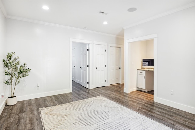 spare room featuring dark hardwood / wood-style flooring and crown molding