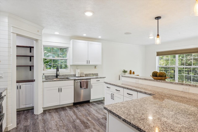 kitchen with pendant lighting, sink, stainless steel dishwasher, light stone countertops, and white cabinetry