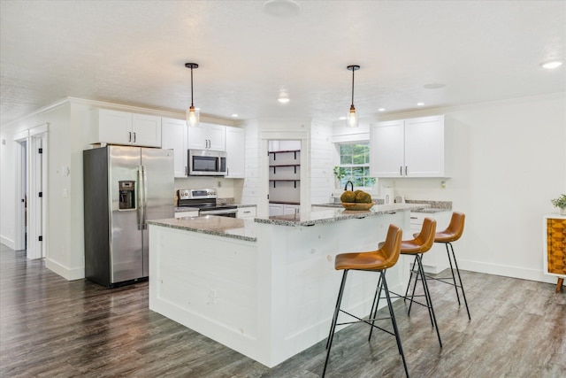 kitchen featuring white cabinetry, a kitchen island, pendant lighting, and appliances with stainless steel finishes