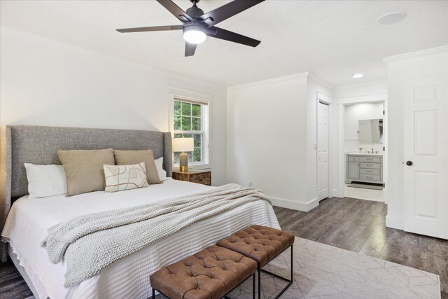 bedroom featuring ornamental molding, connected bathroom, ceiling fan, and dark wood-type flooring