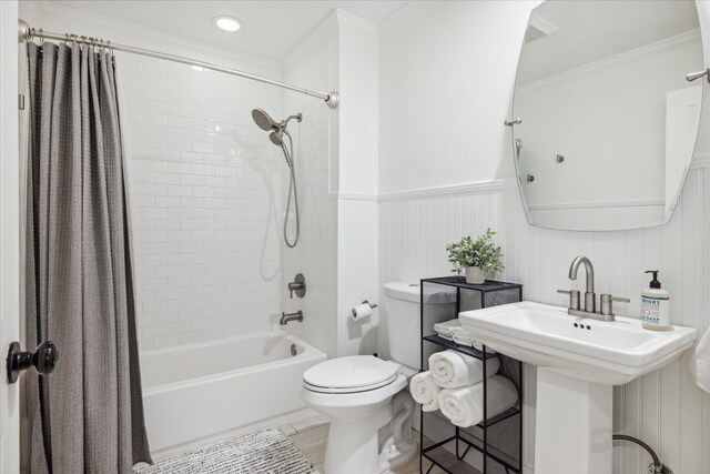 full bathroom with shower / tub combo, ornamental molding, wooden walls, sink, and toilet