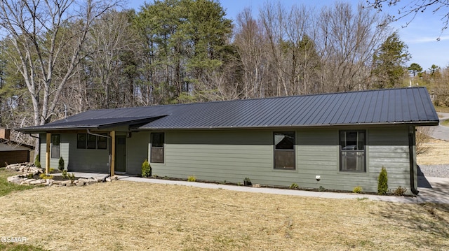 ranch-style home with a front lawn and metal roof