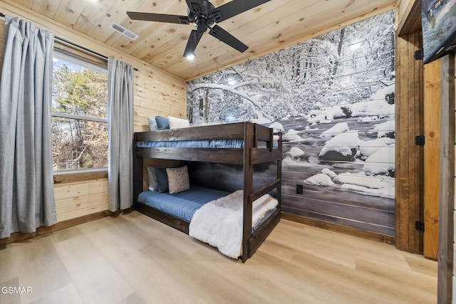 bedroom featuring visible vents, wood walls, wooden ceiling, and wood finished floors