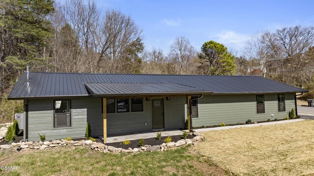 view of front of home with metal roof and a front yard