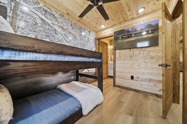 bedroom with light wood-style floors, wooden ceiling, and wooden walls