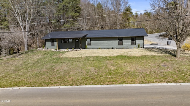 view of front of house with metal roof and a front lawn