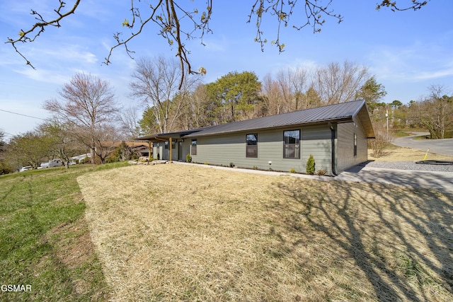 view of property exterior with metal roof and a yard