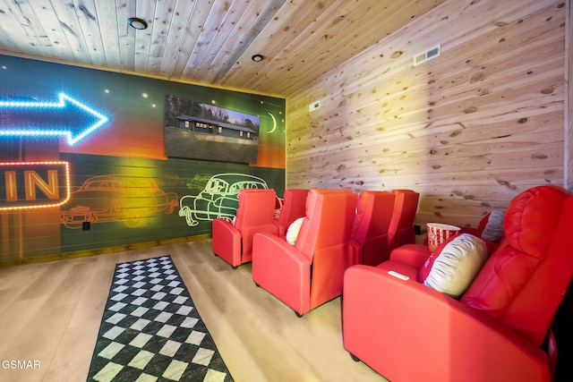 cinema room with visible vents, wood ceiling, wood finished floors, and wood walls