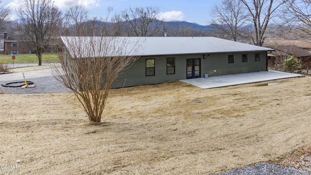 back of property featuring a patio and metal roof