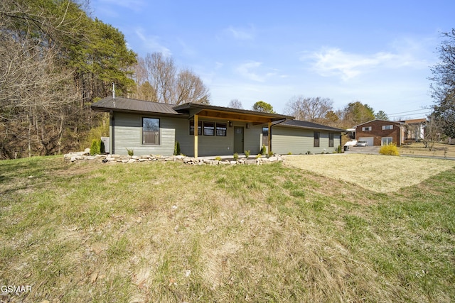 rear view of property featuring a yard and metal roof