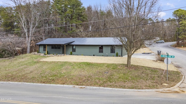 view of front of property with metal roof and a front lawn