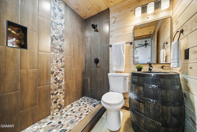 full bath with vanity, toilet, wood walls, and a tile shower