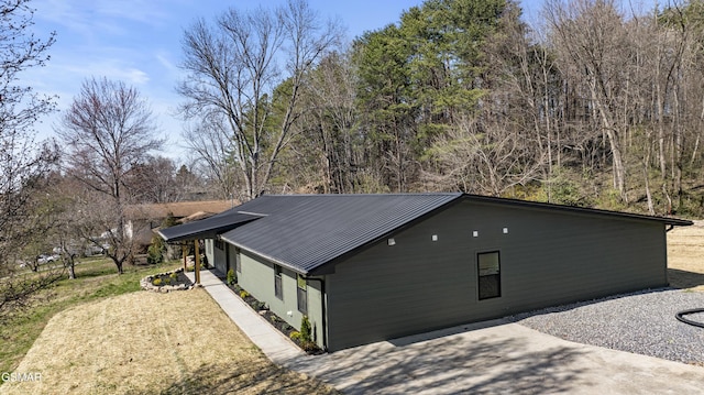 view of home's exterior with metal roof and a yard