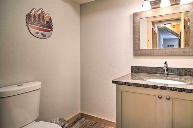 bathroom with vanity, wood-type flooring, and toilet