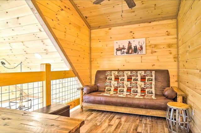 sitting room with wood ceiling, vaulted ceiling, ceiling fan, hardwood / wood-style floors, and wood walls