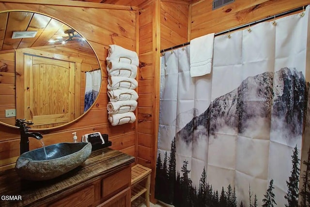 bathroom with visible vents, wood walls, vanity, and a shower with shower curtain