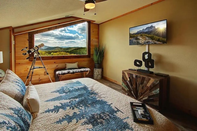 bedroom with crown molding, wooden walls, and ceiling fan