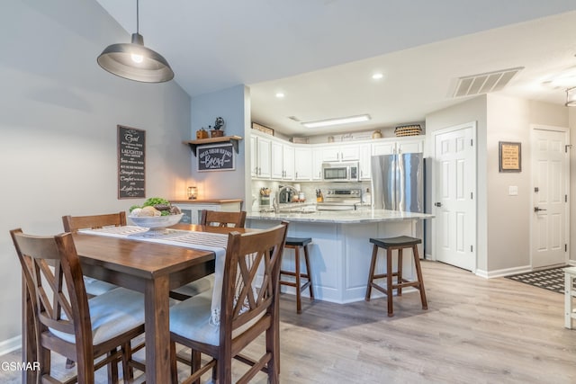 dining area featuring sink and light wood-type flooring