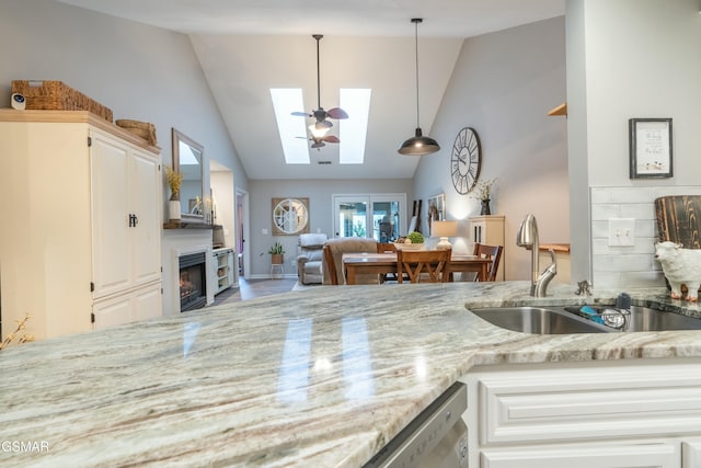 kitchen featuring white cabinetry, sink, and hanging light fixtures