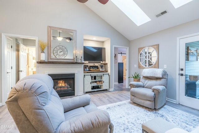 living room featuring ceiling fan, high vaulted ceiling, and light hardwood / wood-style flooring